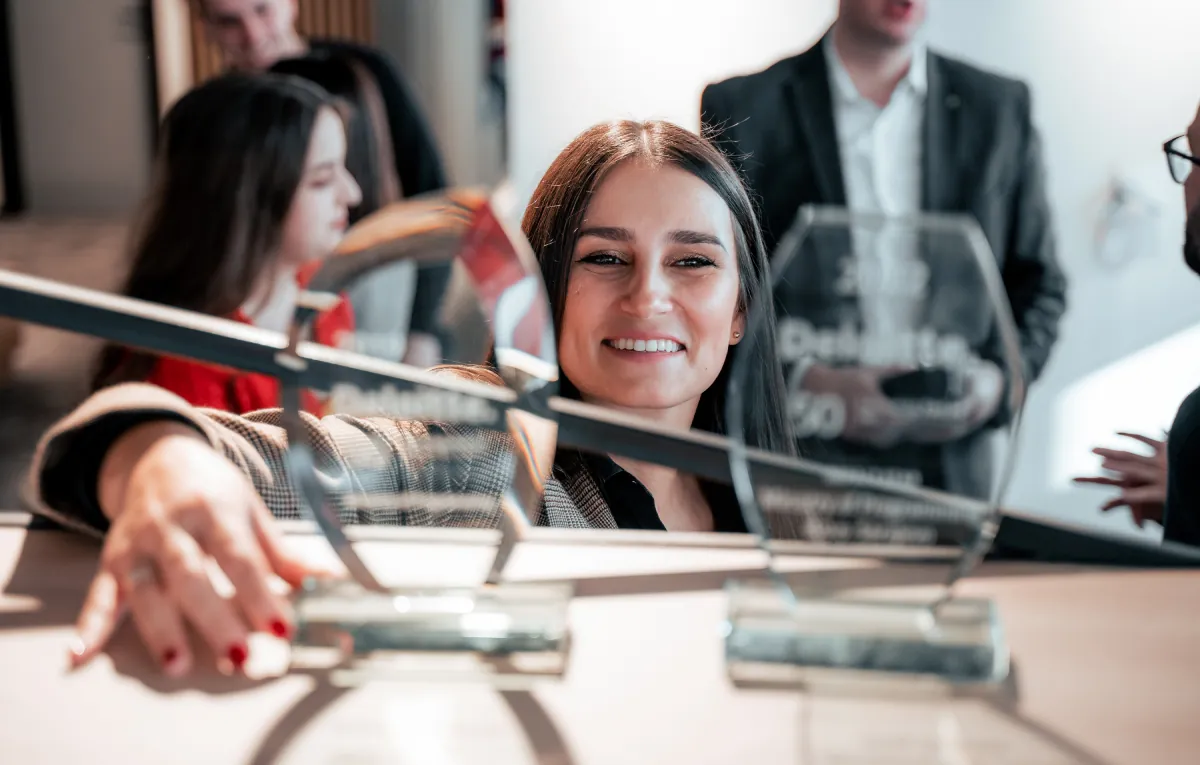 Ministry of Programming co-founder and CMO placing the Deloitte Impact Star award on a shelf in the office, marking a proud milestone for the company.