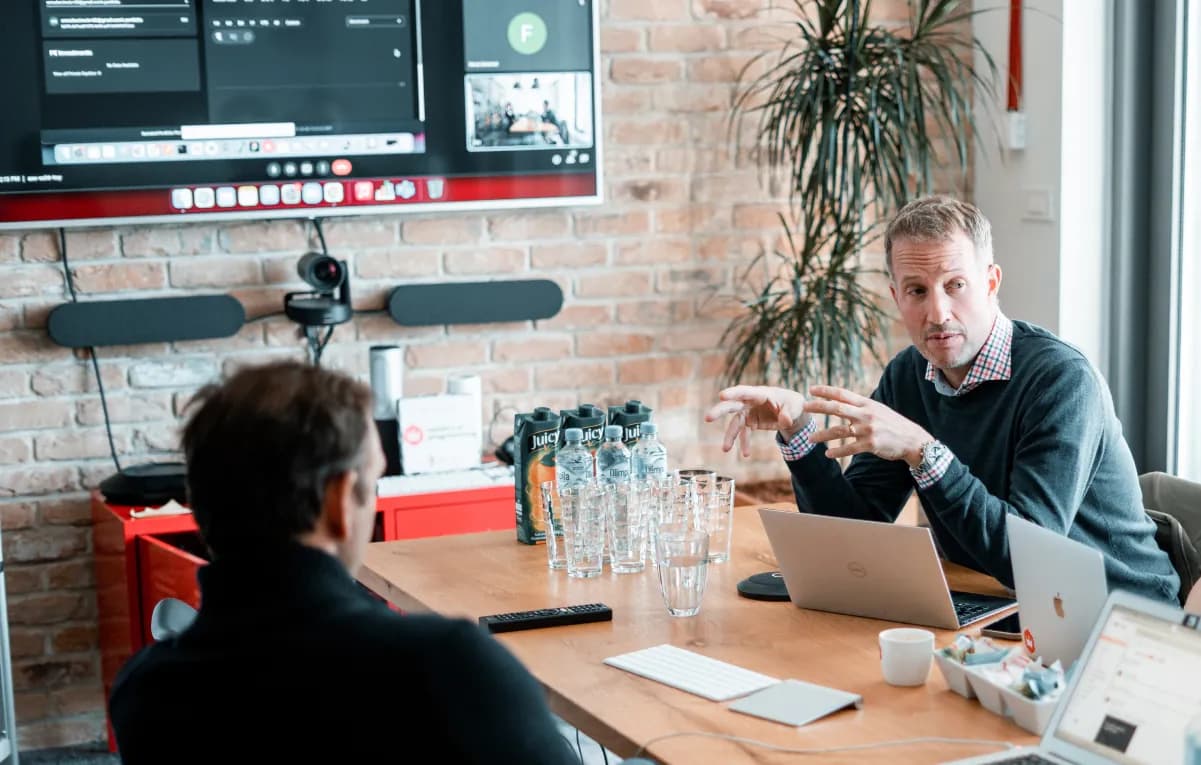 Team members and clients discussing product design in a modern Ministry of Programming conference room.