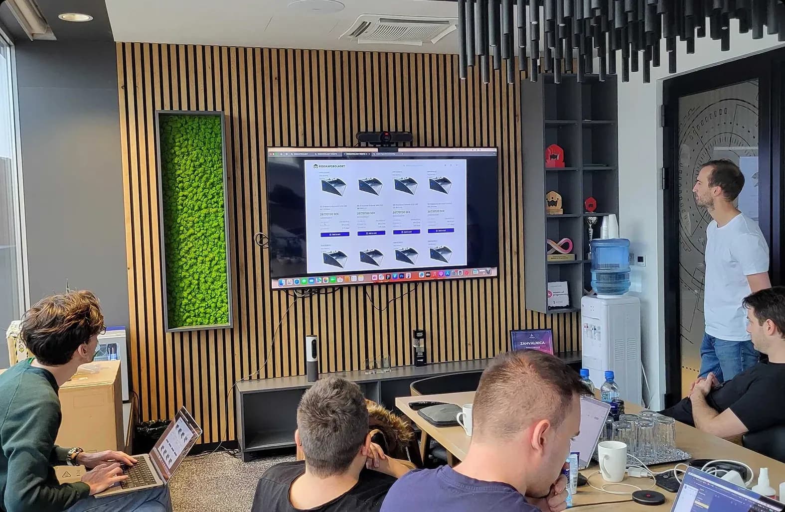 Team reviewing a digital product interface on a screen during a brand system alignment session, ensuring consistent UI patterns and visual identity.